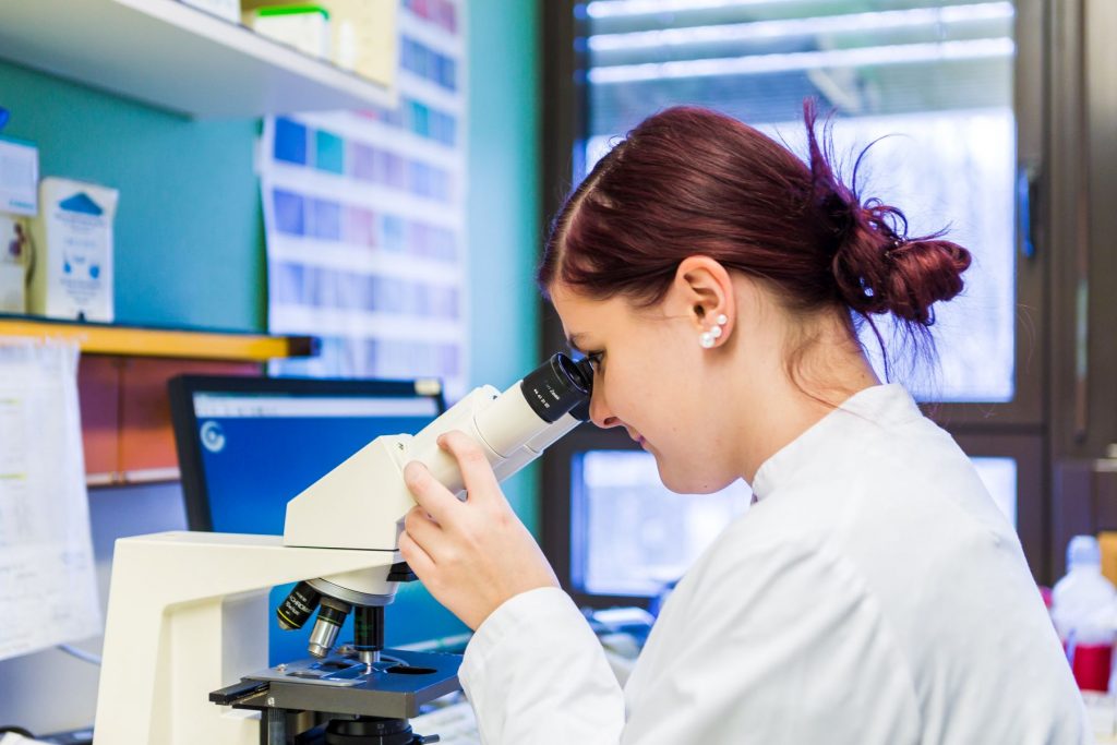Eine Mitarbeiterin des Labors im Klinikum Ingolstadt blickt durch ein Mikroskop.