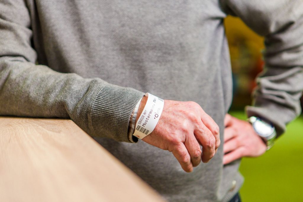 Ein älterer Herr trägt am rechten Handgelenk ein Patientenarmband des Klinikums Ingolstadt