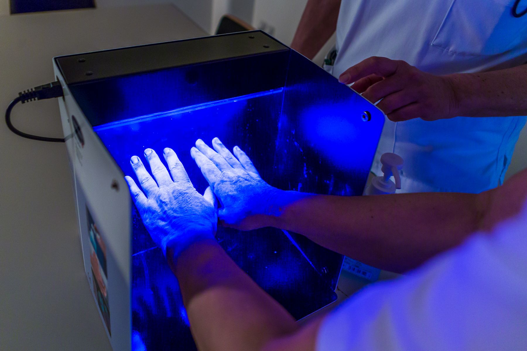 Unter einer UV-Lampe wird getestet, ob man sich die Hände richtig desinfiziert hat