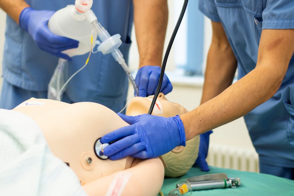 Intubation und Abhören mit dem Stethoskop an einer Puppe