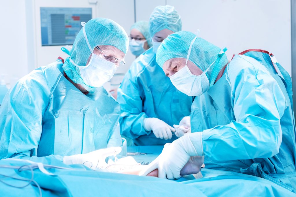 Zwei Unfallchirurgen des Klinikums Ingolstadt operieren einen Patienten am Bein
