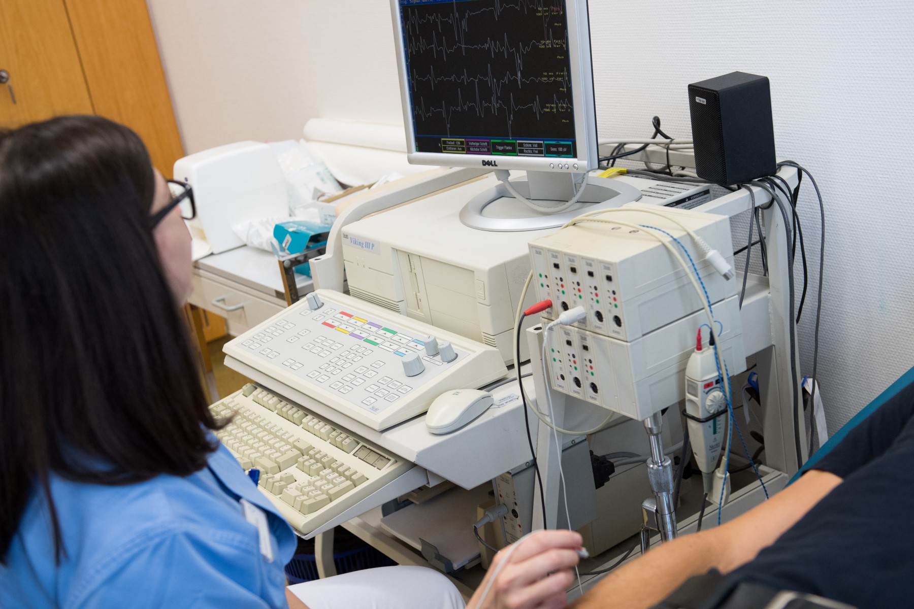 Eine Ärztin führt eine Elektromyographie an einem Patienten durch