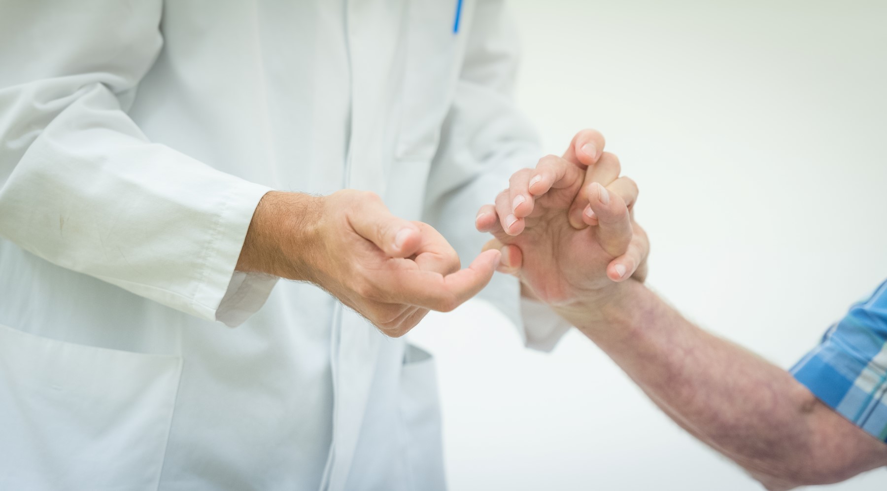 Neurologie - ein Arzt testet die Reflexe an den Fingern eines Patienten