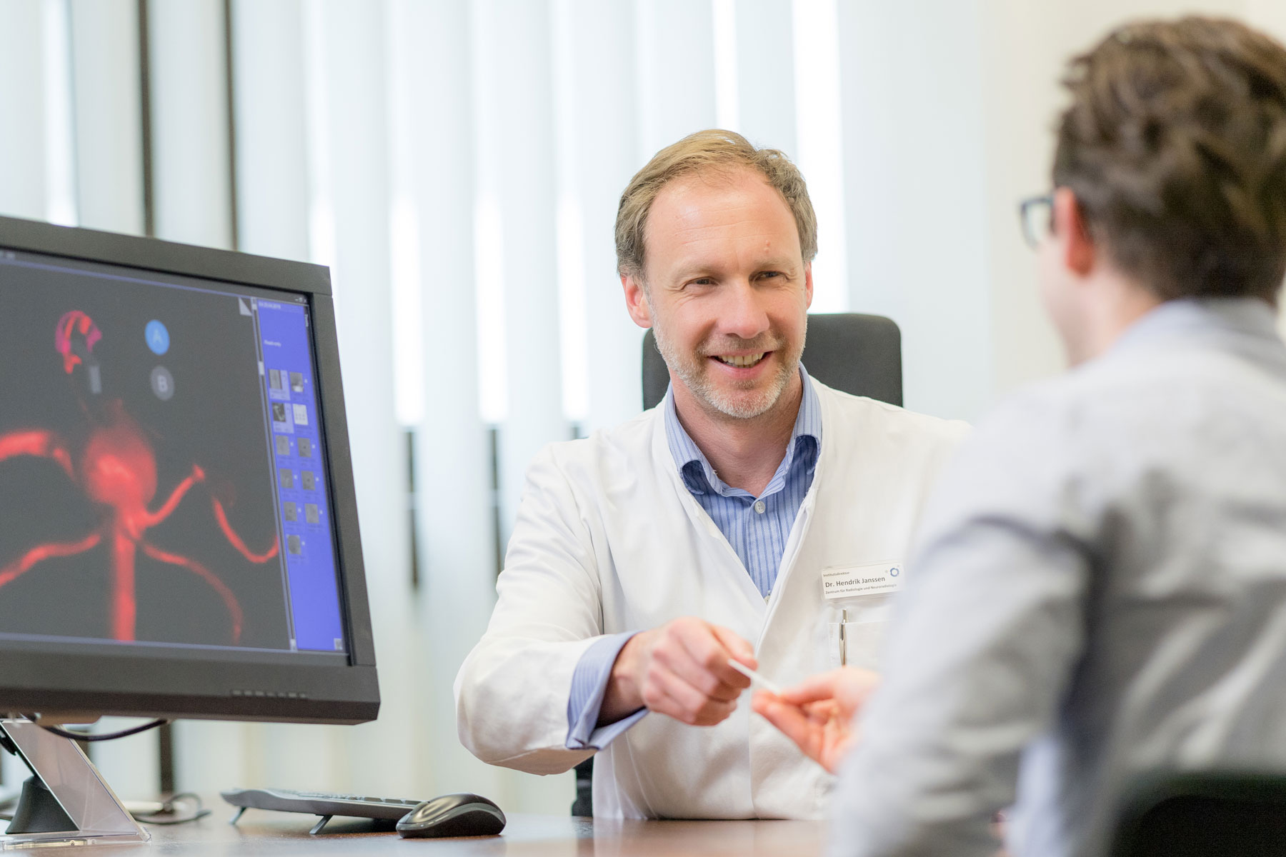 Dr. Hendrik Janssen im Gespräch mit einem Patienten.